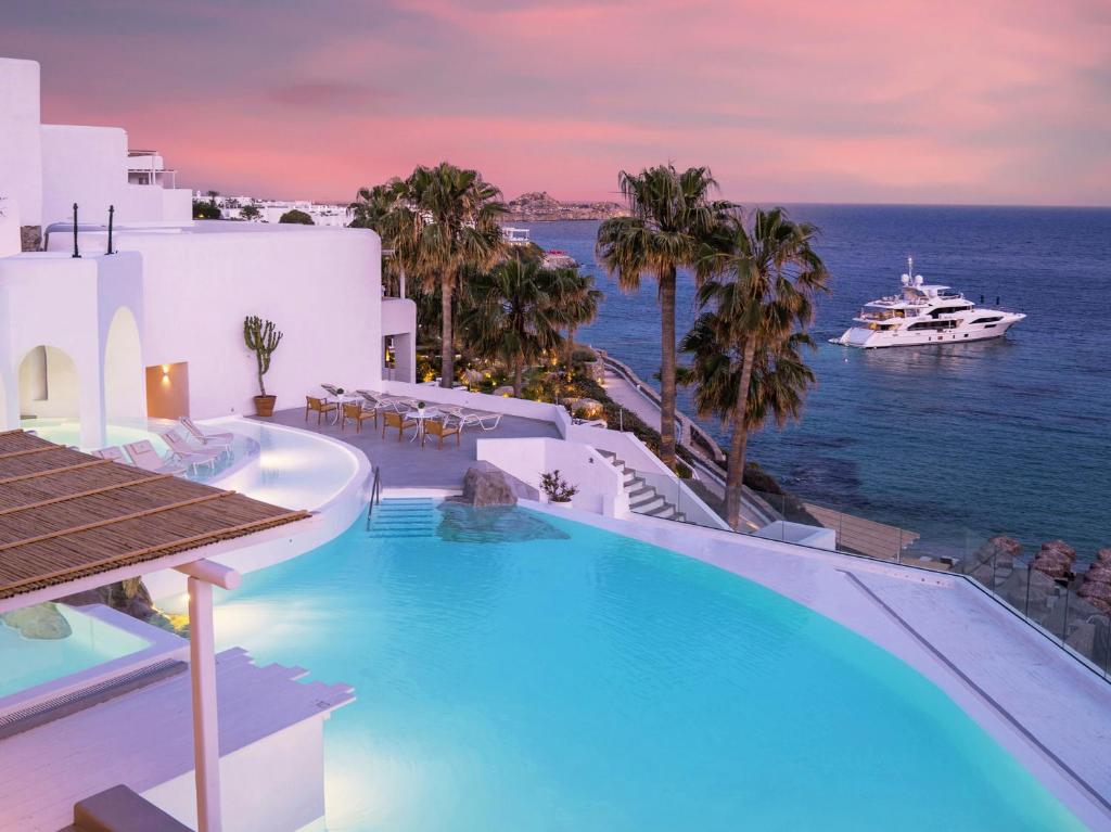 a swimming pool with a view of the ocean at Mykonos Blu, Grecotel Boutique Resort in Psarou