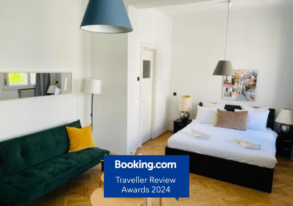 Un dormitorio con una cama y un sofá verde. en Cismigiu Park View, en Bucarest