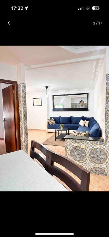 uma sala de estar com um sofá azul num quarto em Appartement meublé em Rabat