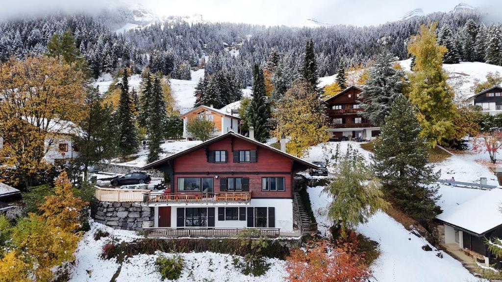 a large red house with snow on the ground at Chalet Rose Bay in Leysin