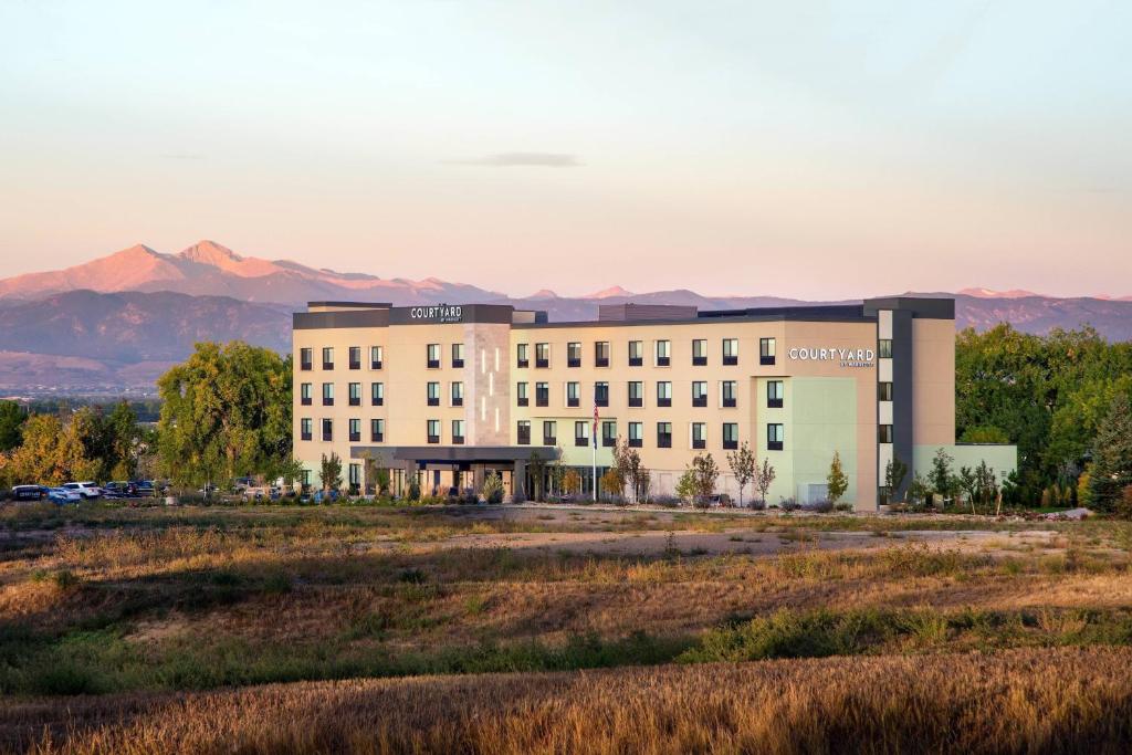 a rendering of a building with mountains in the background at Courtyard by Marriott Loveland Fort Collins in Loveland