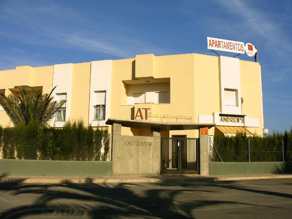 a white building with a sign on top of it at Apartamentos turisticos Andrew´s in Puerto de Mazarrón