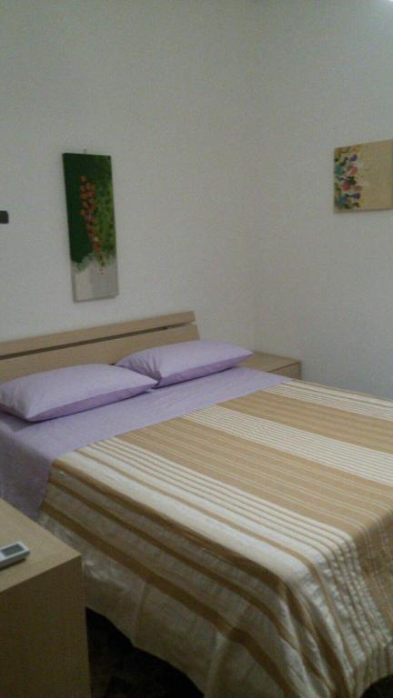 a bedroom with a large bed with purple pillows at B&B SanteBice in Polignano a Mare