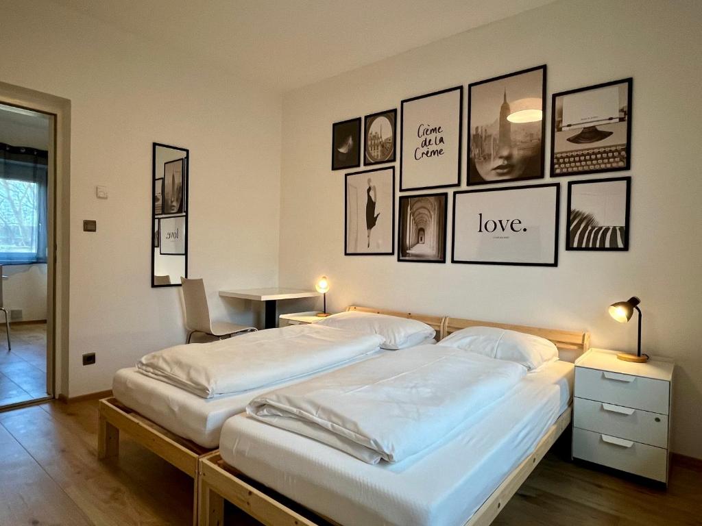 two beds in a room with pictures on the wall at sHome CityHouse Graz - Self-Check-in in Graz
