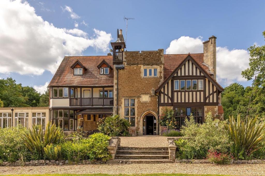 una vecchia casa di mattoni con una scala di fronte di Farnham House Hotel a Farnham