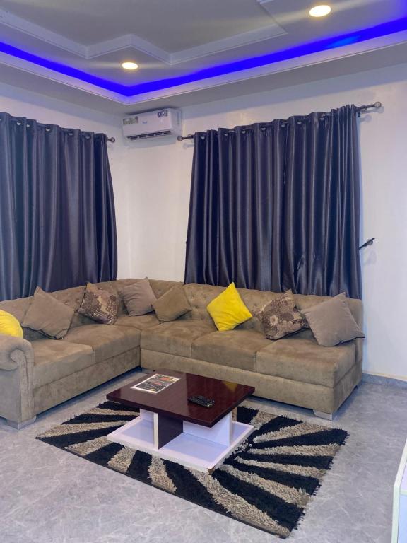 uma sala de estar com um sofá e uma mesa de centro em Luxistt em Enugu