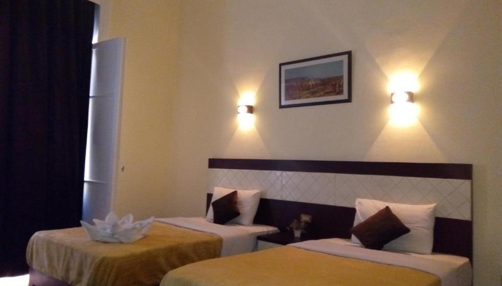 Postel nebo postele na pokoji v ubytování Cairo Paradise Hotel