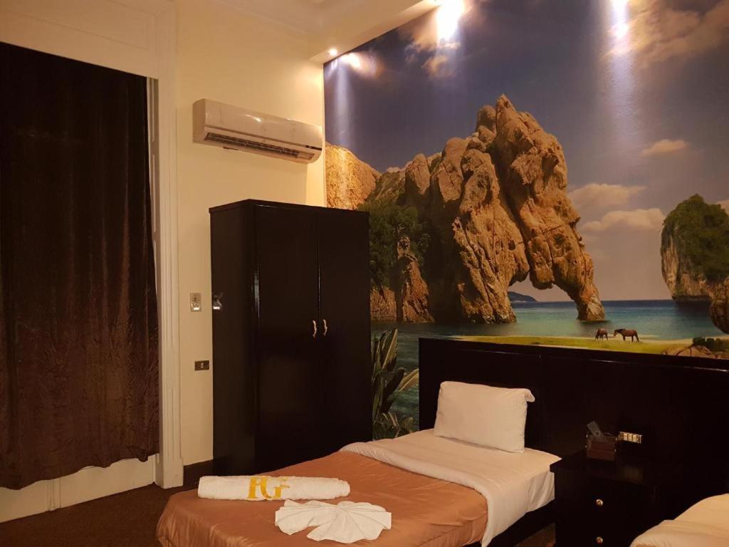 a bedroom with two beds and a painting on the wall at Cairo Paradise Hotel in Cairo