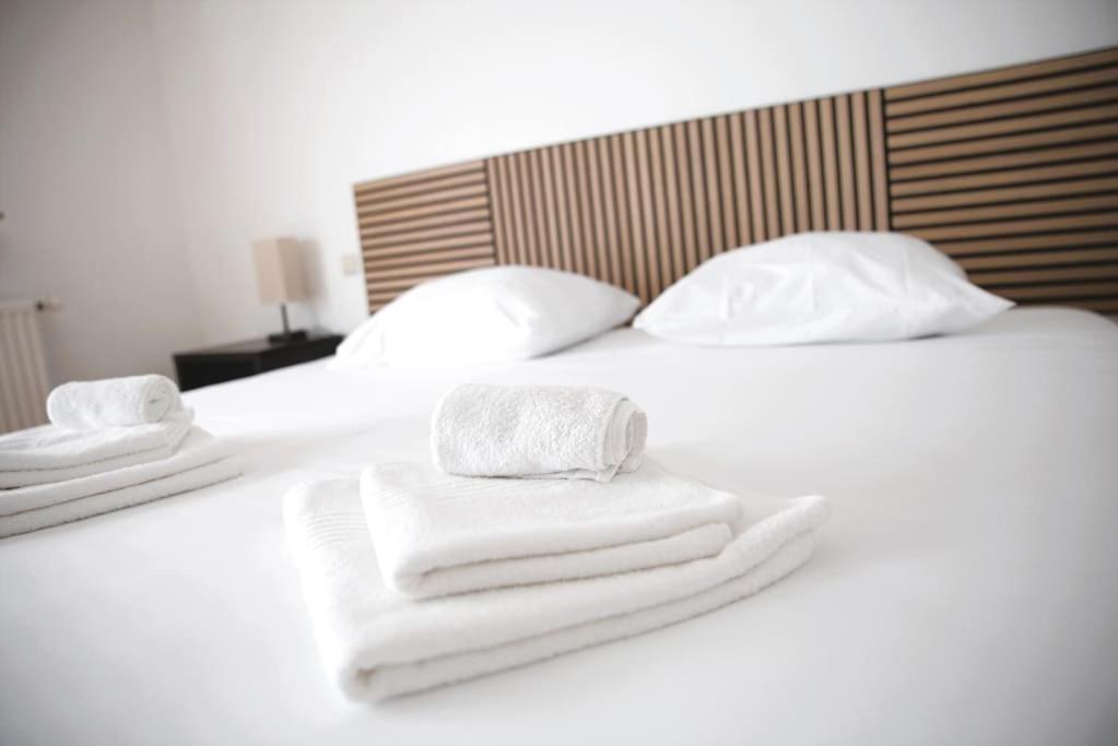 two towels are stacked on a white bed at Cozy 3 bedroom house with 11 kw electric car charger in Hesperange