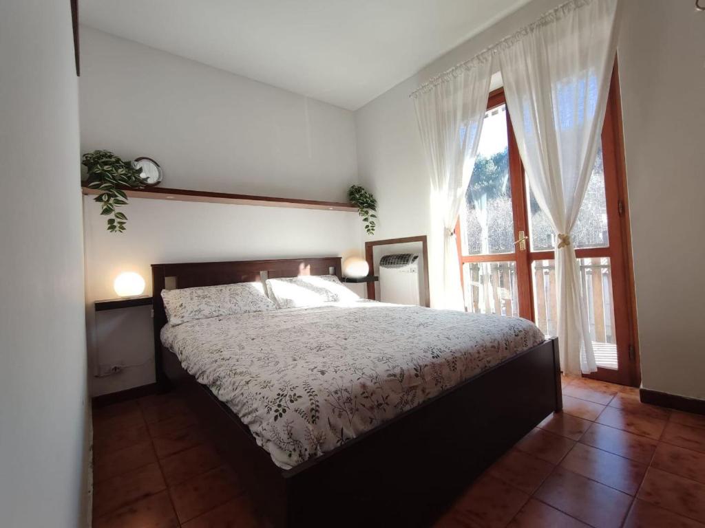 - une chambre avec un lit et une grande fenêtre dans l'établissement MadreSila Home, à Camigliatello Silano