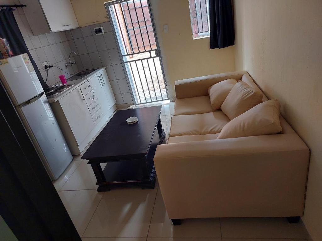 ein Wohnzimmer mit einem Sofa und einem Tisch in der Unterkunft BERG STREET APARTMENTS in Johannesburg