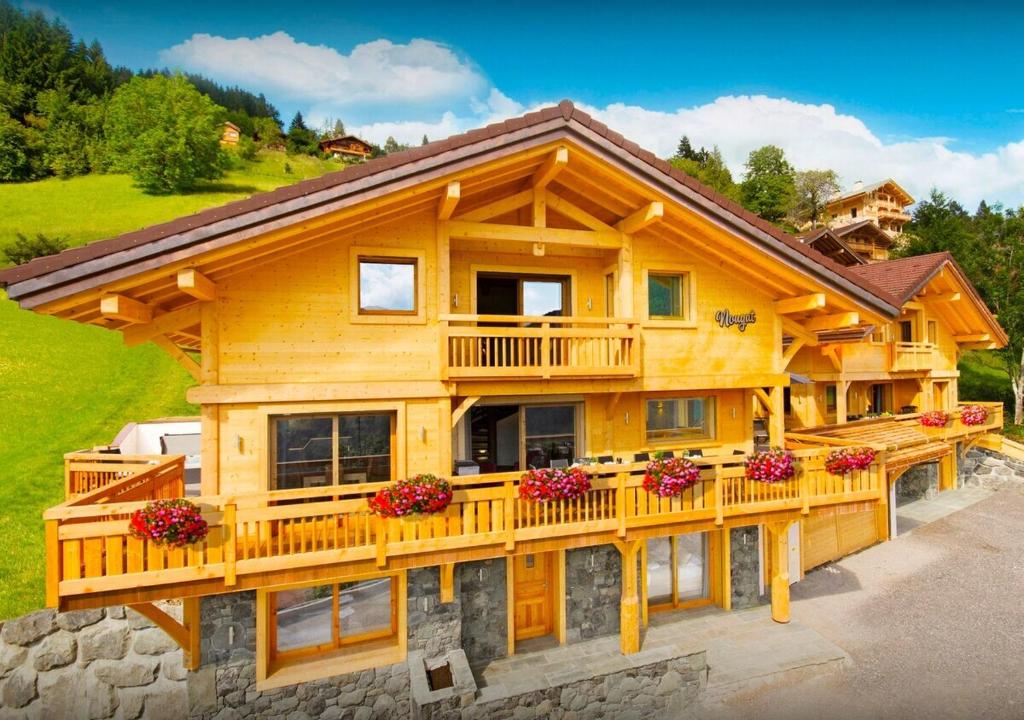 a large wooden house with a balcony at Chalet Nougat - Les Congères in Manigod