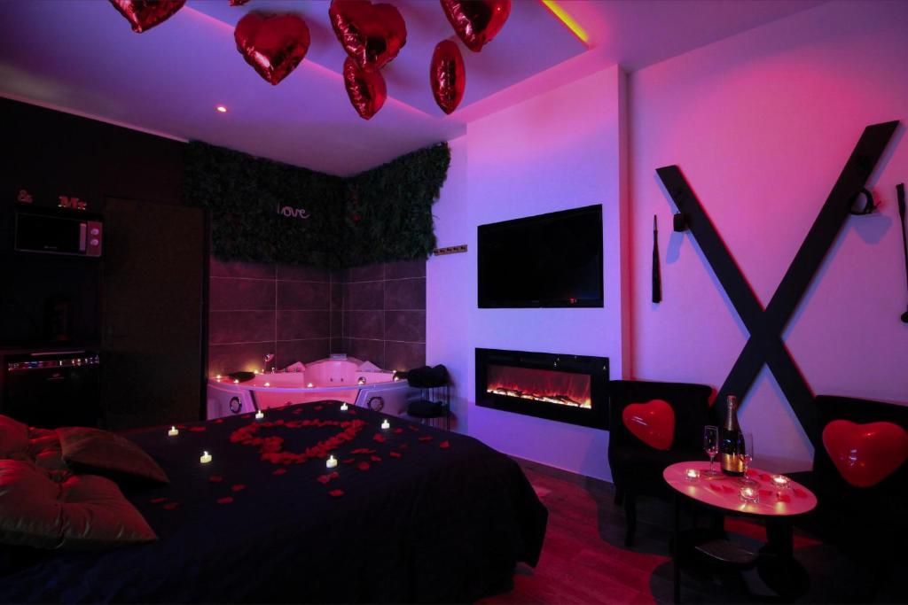 una camera da letto con luci viola, un letto e un camino di LoveroomXspa a Bourg-Saint-Christophe