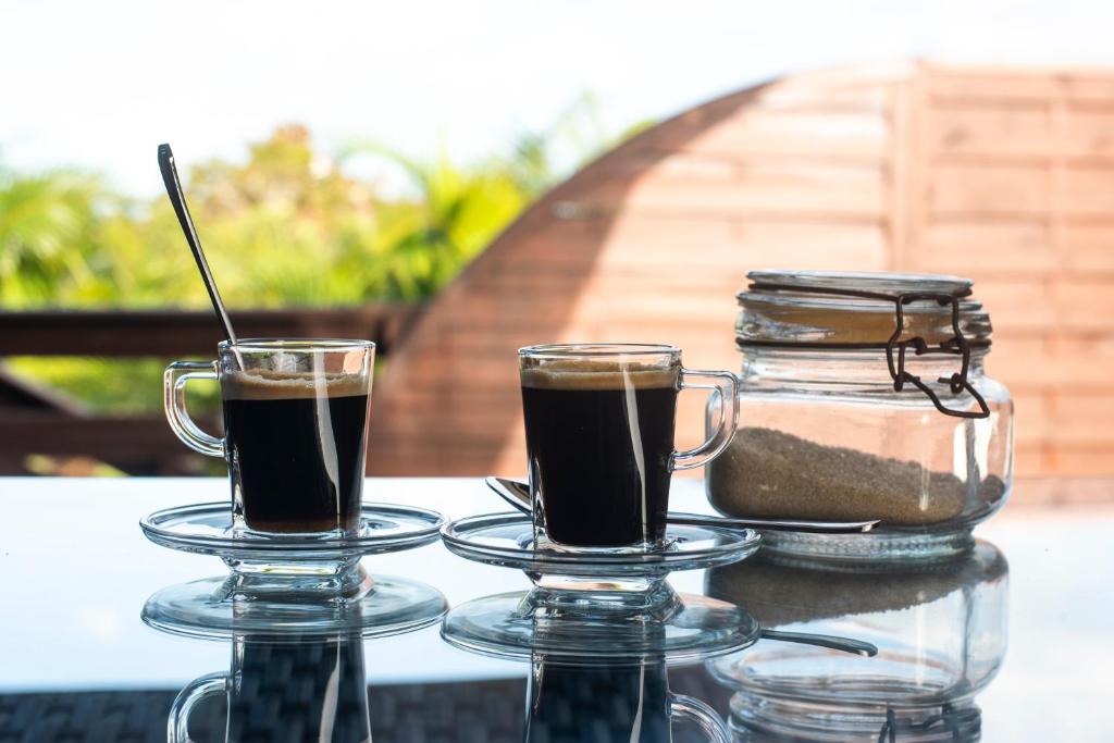dos vasos de café sentados en una mesa en La Bitasyon Tirisyl, en Capesterre