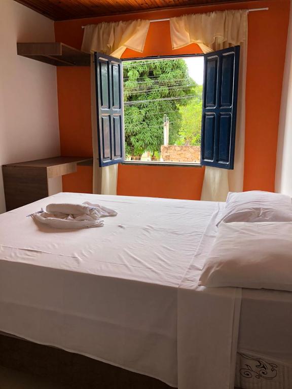 a bedroom with a large bed with a window at Pousada Brilho da Chapada New in Lençóis