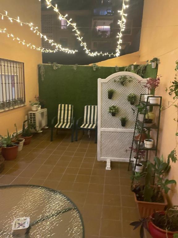 Habitación con 2 sillas, luces y plantas en Luchana 15, en Málaga