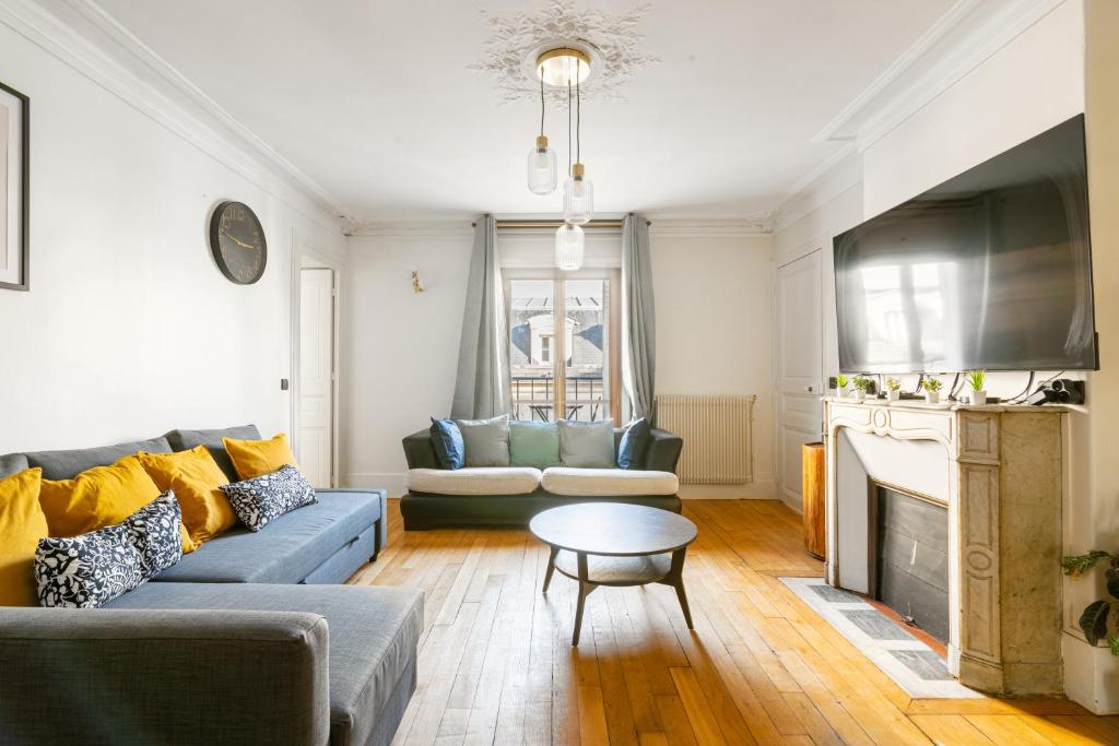 a living room with a couch and a table at Appartement Quartier la Madeleine Free Netflix in Paris