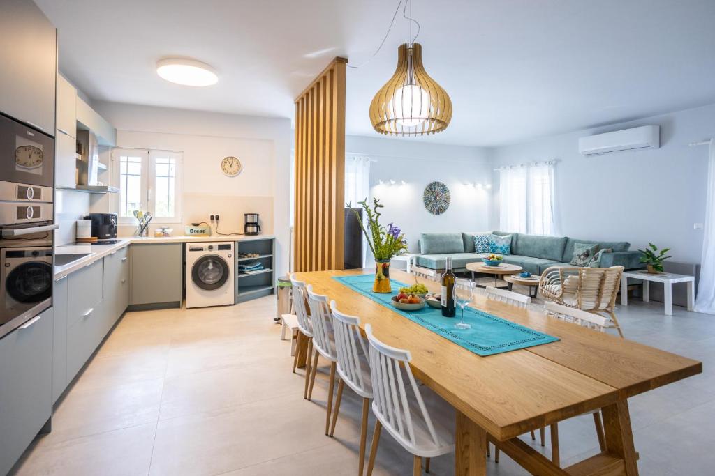 uma cozinha e sala de estar com uma mesa de madeira e cadeiras em Casa George em Rethymno Town