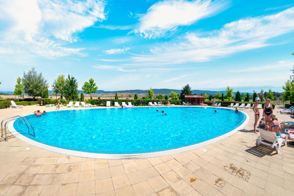 a pool at a resort with people swimming in it at Holiday and Orchid Fort Noks Apartments in Sunny Beach