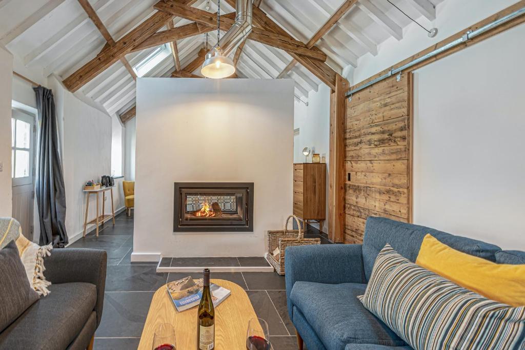 a living room with two couches and a fireplace at Snowdonia Glamping Holidays, Betws-y-Coed in Betws-y-coed