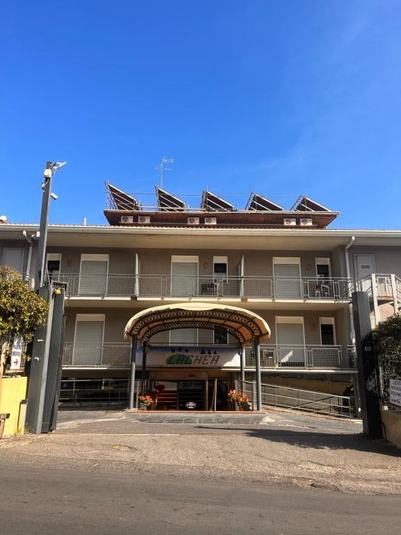 a large building with an archway in front of it at Hotel Lachea in Acitrezza