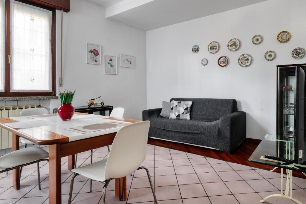 - un salon avec une table, des chaises et un canapé dans l'établissement Extra Comfort - Casa Vicino a Milano e Linate, à Zelo Buon Persico