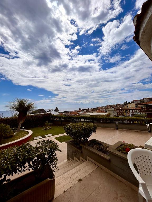 a patio with a view of the ocean under a cloudy sky at Hotel Lachea in Acitrezza