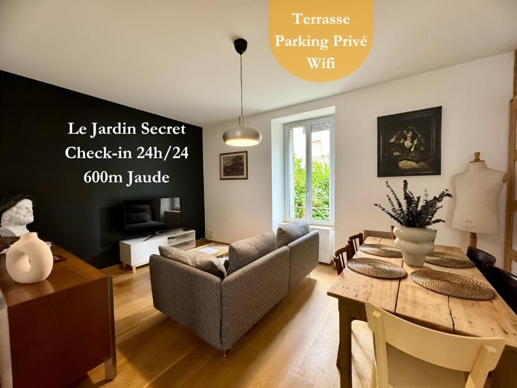 a living room with a table and a couch at Le Jardin Secret in Clermont-Ferrand