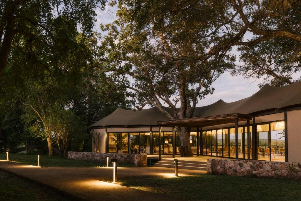 a large building with lights on the grass at Zambezi Sands by Batoka in Victoria Falls