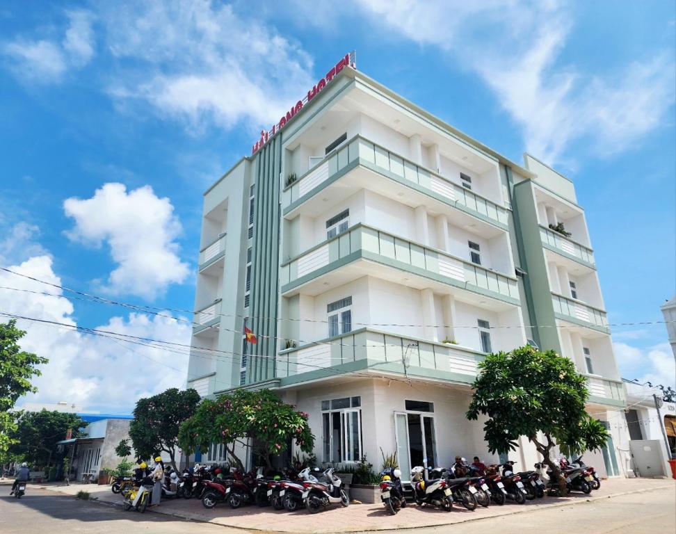 um edifício branco com um monte de motos estacionadas na frente em Hải Long Hotel Đảo Phú Quý em Cu Lao Thu