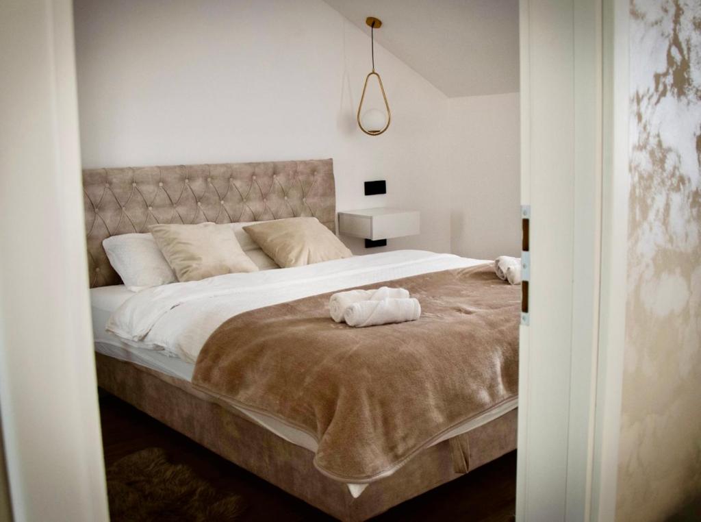 a bedroom with a large bed with two towels on it at Apartman Star #2 in Vinkovci