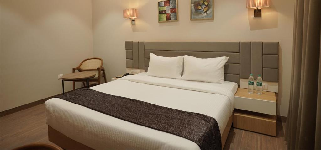 a bedroom with a large bed and a chair at Hotel Alwar Royals in Alwar