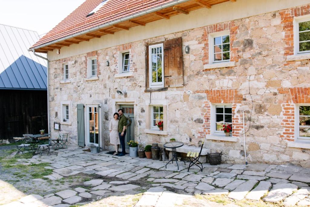 un hombre parado en la puerta de una casa de piedra en Dwie Brzozy wegetariańskie siedlisko, en Wleń