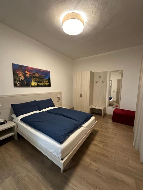 a bedroom with a large bed with a blue blanket at Residenza Pezzani in Parma