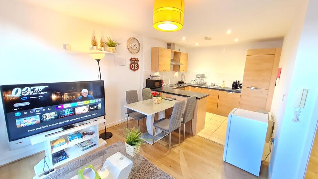 a living room with a table and a tv and a kitchen at Excellent 2 Bedroom City Centre Apartment in Sheffield