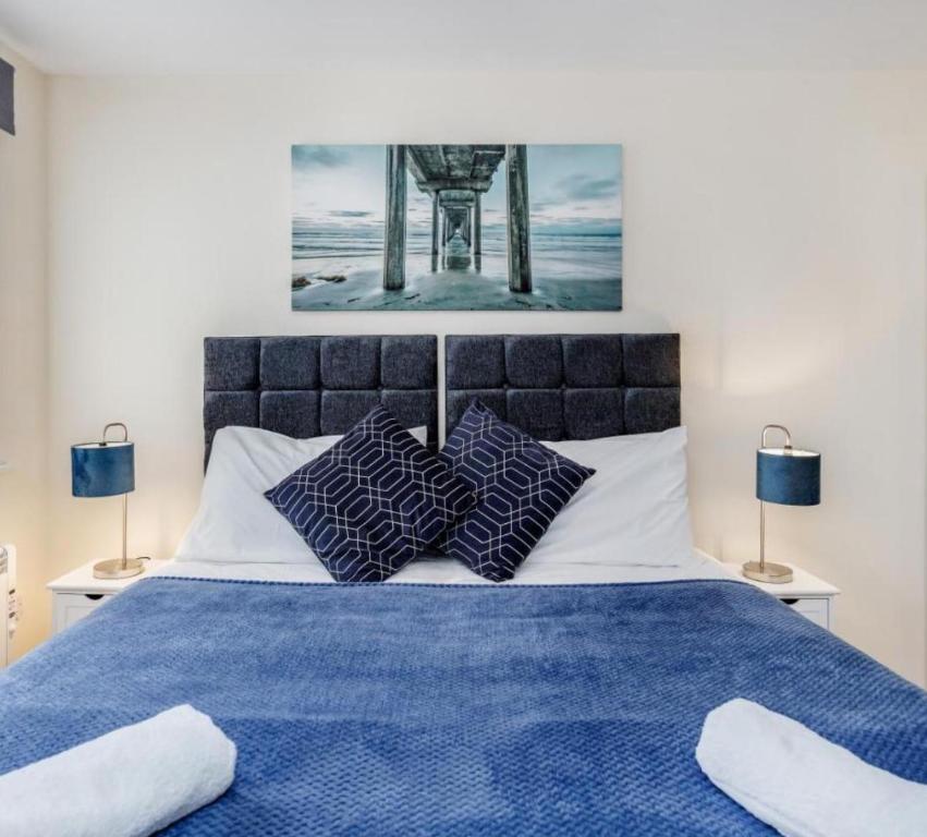 a bedroom with a blue bed with two lamps at Zs Apartments - St Albans City Centre - 20 mins from London in St. Albans