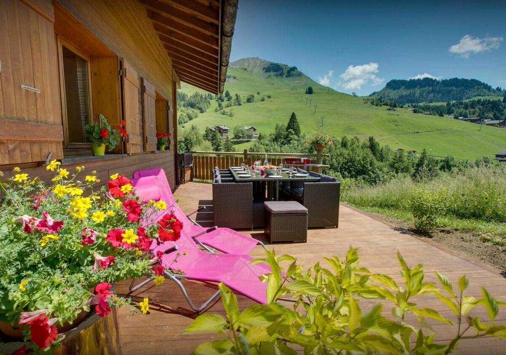 a patio with a table and chairs and flowers at Chalet Sicoria - Les Congères in Le Grand-Bornand