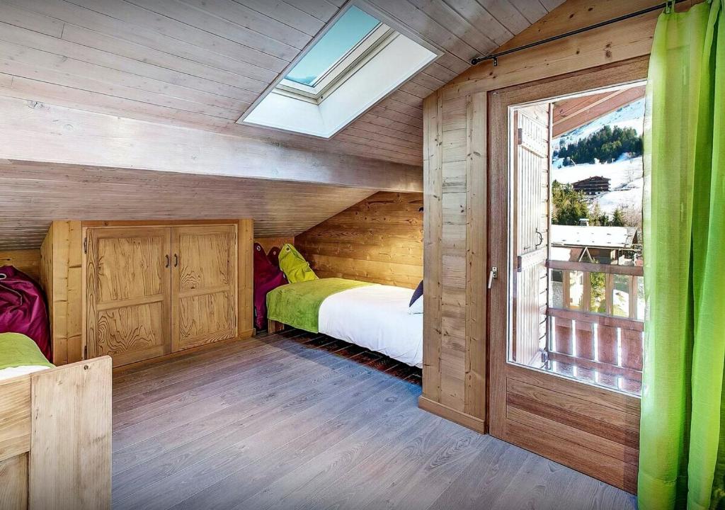 a bedroom with two beds and a window at Chalet Sicoria - Les Congères in Le Grand-Bornand