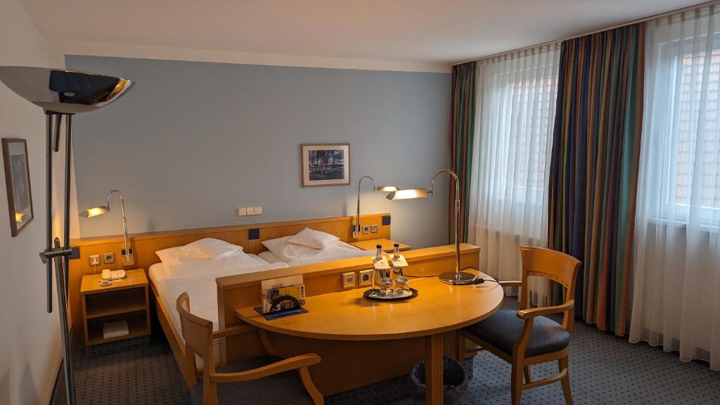 una camera d'albergo con tavolo e letto di Hotel Gasthof Lang a Balingen