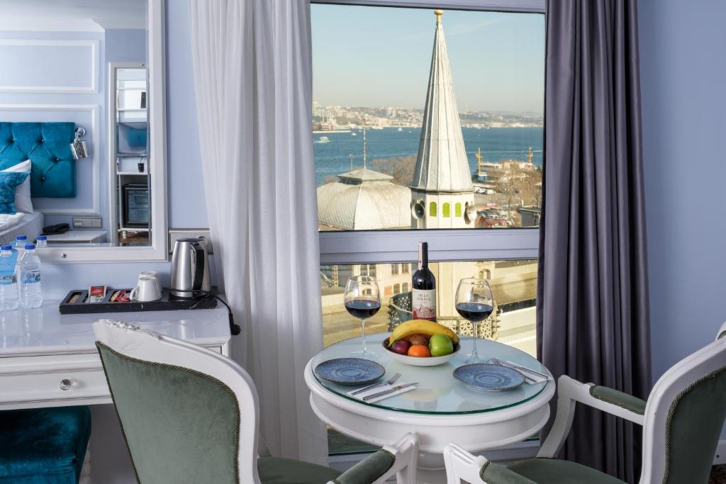 un tavolo con un cesto di frutta e bicchieri da vino di Glamour Hotel Istanbul Sirkeci a Istanbul