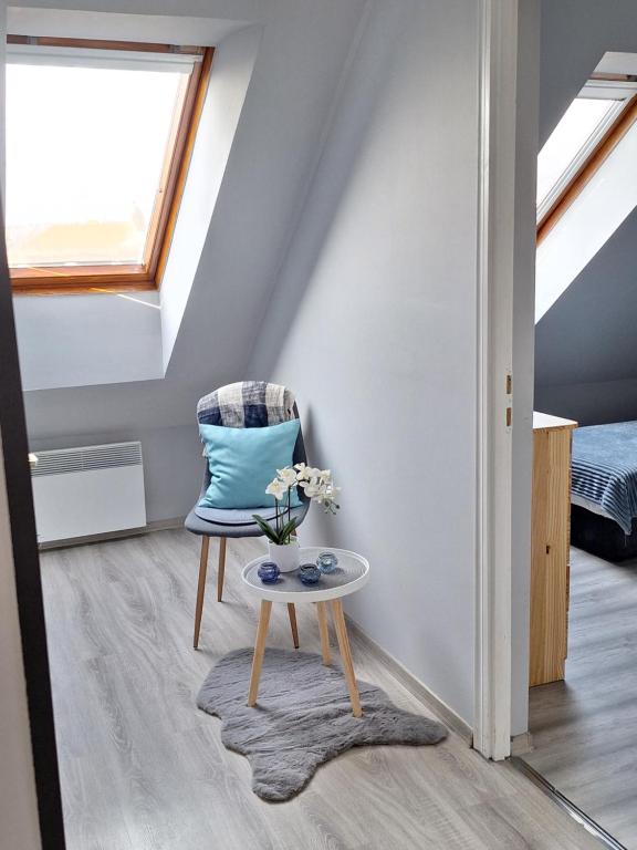 a room with a chair and a table at Várfal apartman II in Eger