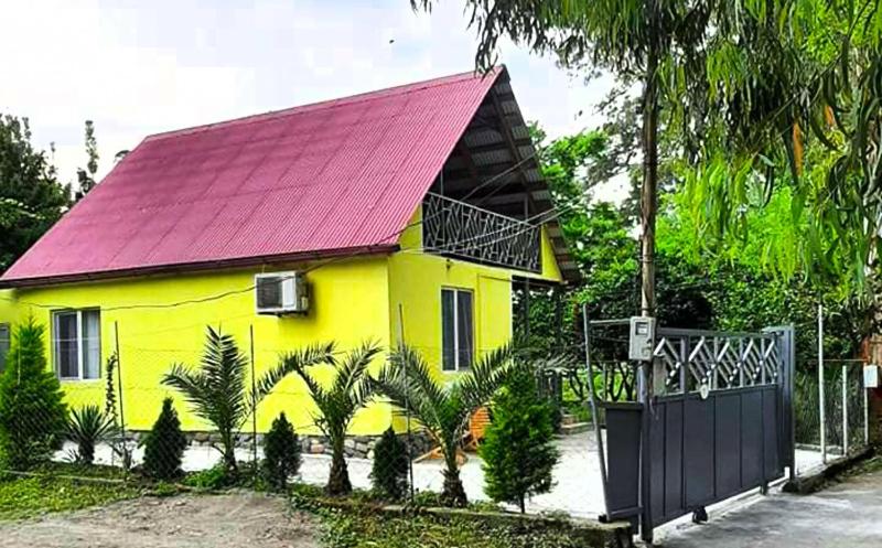 a yellow house with a red roof and a gate at Yellow chalet 021. in Batumi