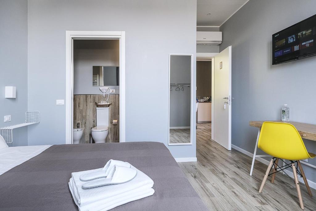 Zimmer mit einem Bett und einem gelben Stuhl in der Unterkunft Al Binario Brescia in Brescia