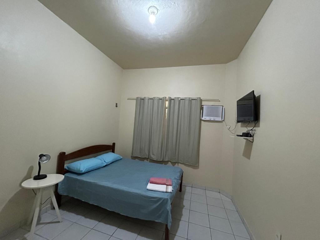 a small bedroom with a bed and a tv at Apto próximo à Polícia Federal in Manaus