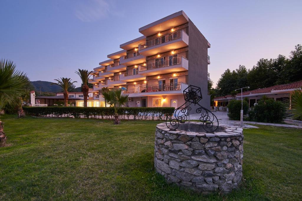 a large building with a statue in front of it at Hotel Sarti Beach in Sarti