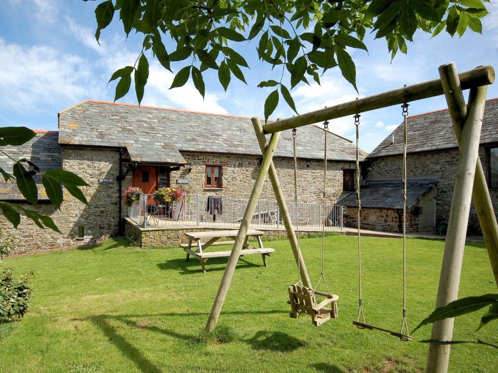 a swing in front of a stone building at 3 Bed in Bude CORYM in Morwenstow