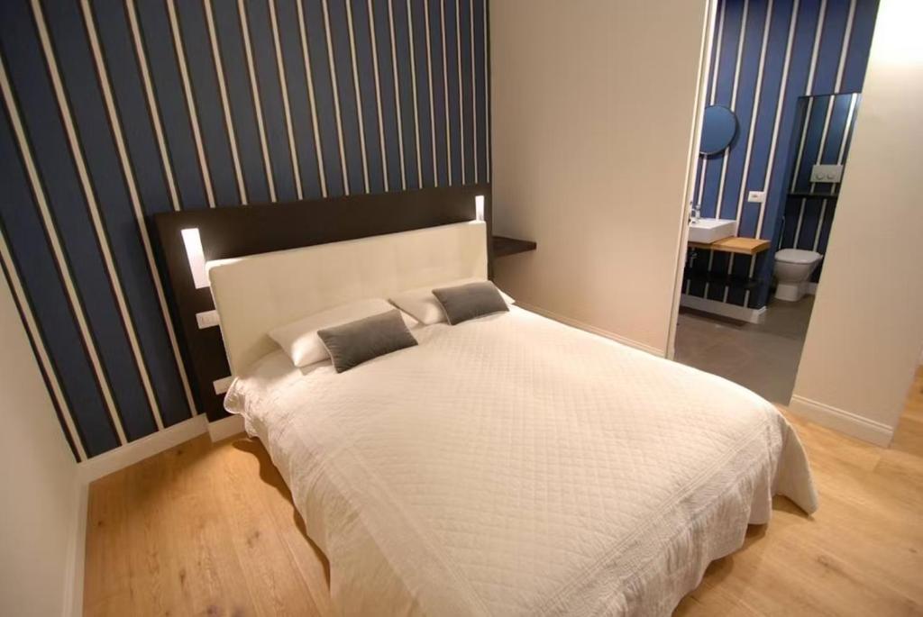 TB-One bedroom luxury apartment in the fashion district في فلورنسا: غرفة نوم بسرير ابيض مع وسادتين