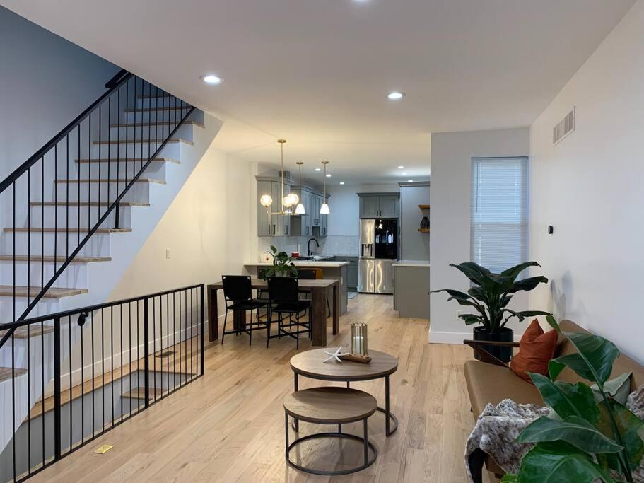 a living room with a staircase and a table and a kitchen at A Hidden Gem in Philadelphia