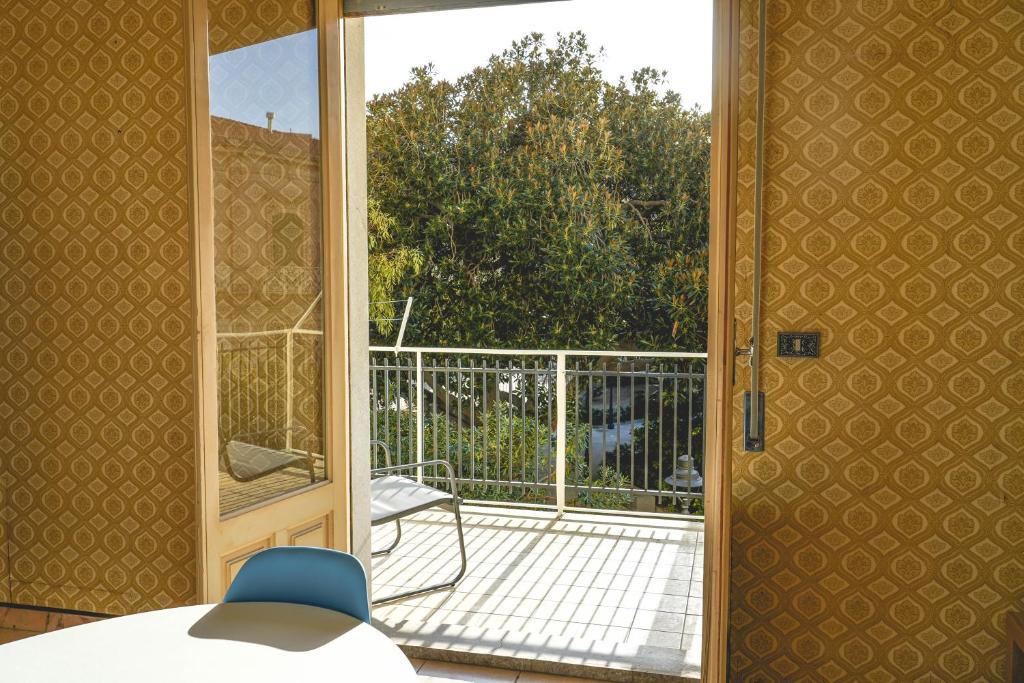 una puerta abierta a un patio con balcón en Casa della Villa Pozzallo en Pozzallo