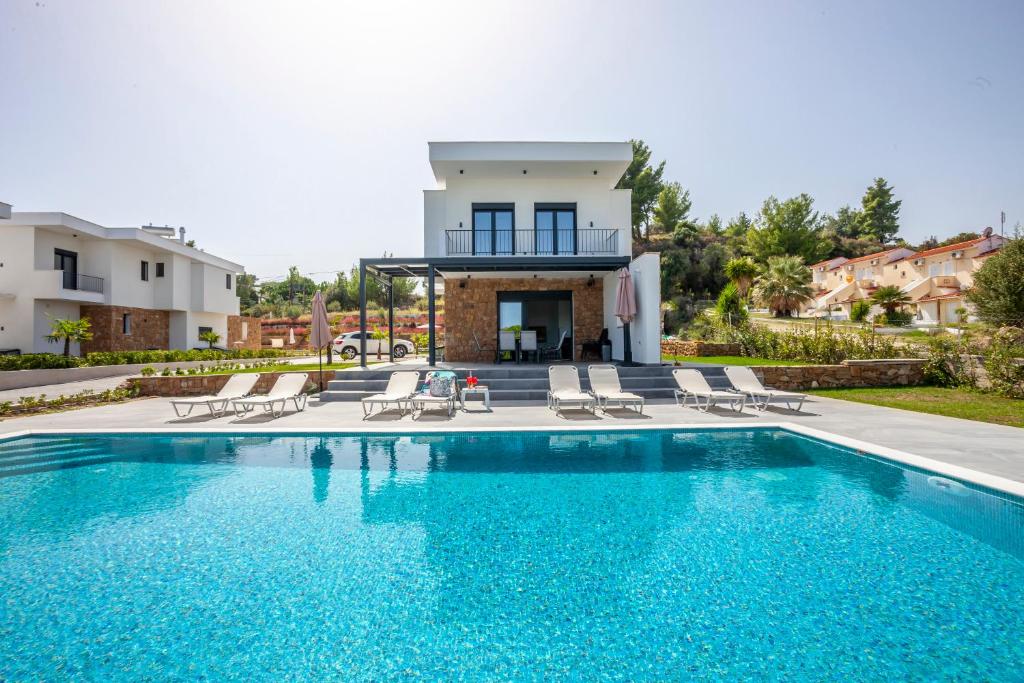 una villa con piscina e una casa di Megan Luxury villa with private pool a Pefkohori